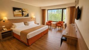 a hotel room with a bed and a table and chairs at Xelena Hotel & Suites in El Calafate +56 photos