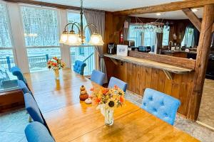 a dining room with a long table and blue chairs at Jay Peak Getaway on Trout River in Montgomery