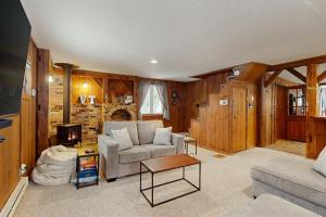 a living room with a couch and a tv at Jay Peak Getaway on Trout River in Montgomery