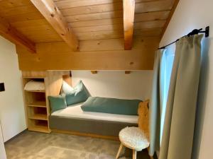 a bunk bed in a room with a wooden ceiling at Ferienhaus Eichenseer Gallzein - Alleinlage mit Garten, Wald & Bergblick in Gallzein