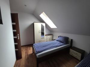 a small bedroom with a bed and a mirror at Willa Kier dom bliźniak 7-osobowy ZE STREFĄ BASENOWĄ w miejscowości Chocznia NIEDALEKO ZATORU I ENERGYLANDII in Chocznia +11 photos