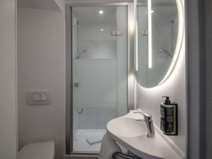 a white bathroom with a sink and a shower at ibis budget Nice Aeroport in Nice