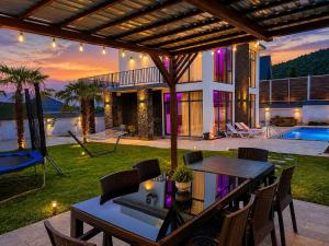 a house with a patio with a table and chairs at Qafqaz Mandarin Deluxe in Gabala