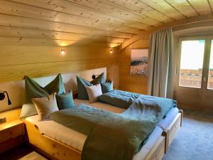 a bedroom with two beds in a wooden room at Ferienhaus Eichenseer Gallzein - Alleinlage mit Garten, Wald & Bergblick in Gallzein