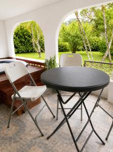 a black table and two white chairs in a patio at La villa fruitier Cavalier in Saint-Laurent du Maroni +24 photos
