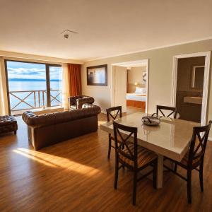 a living room with a table and a couch at Xelena Hotel & Suites in El Calafate