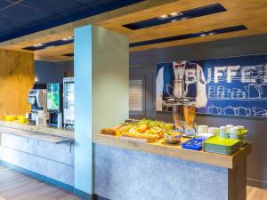 a fast food restaurant with a counter with food at ibis budget Lorient Hennebont in Hennebont
