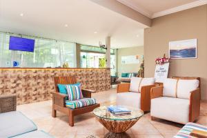 a lobby with a waiting area with chairs and a table at Hotel Pousada Brava Club in Búzios