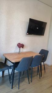 a wooden table with chairs and a vase with flowers on it at Ureki Sun Estate in Ureki