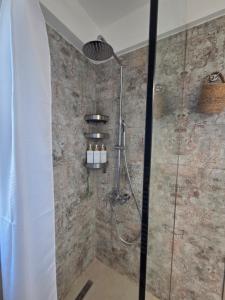 a shower with a glass door in a bathroom at Asteria Houses Samothraki in Samothraki +39 photos