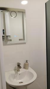a bathroom with a white sink and a mirror at Ureki Sun Estate in Ureki