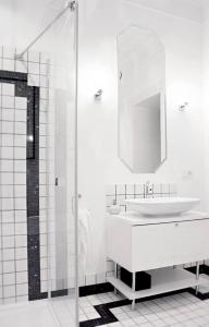 a white bathroom with a sink and a mirror at Regis Residence in Bochnia