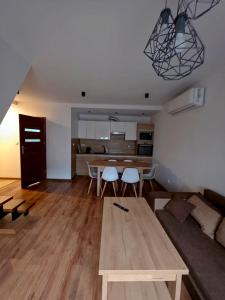 a living room with a couch and a table at Willa Karo dom bliźniak 7-osobowy ZE STREFĄ BASENOWĄ w miejscowości Chocznia NIEDALEKO ZATORU I ENERGYLANDII in Chocznia