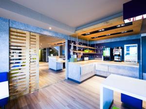a coffee shop with blue walls and wooden floors at ibis Budget Pau Est in Pau