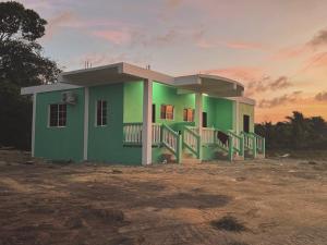 a green building with a sunset in the background at Tees Place in Hopkins