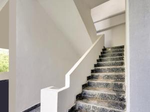a staircase in a house with white walls at Hotel O Hills Land in Warangal