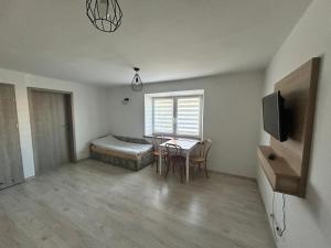a bedroom with a bed and a table and chairs at Królewska Przystań in Kamienica Królewska