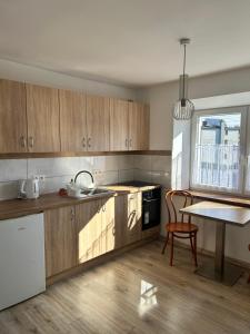 a kitchen with wooden cabinets and a table and a dining room at Królewska Przystań in Kamienica Królewska +11 photos