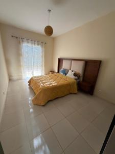 a bedroom with a bed and a large window at Superbe Appartement Bord de mer in Bouznika +14 photos