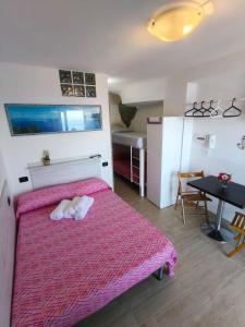 a bedroom with a pink bed with two towels on it at Scilla Chianalea Suite Mare1 in Scilla