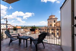 a balcony with two chairs and a table and a building at AuraVista in Montefiascone