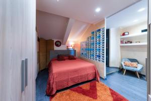 a small bedroom with a red bed and a chair at AuraVista in Montefiascone