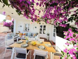 a dining room with a table and purple flowers at VILLA AMIRA ,Marbella Estepona in Benahavís +39 photos