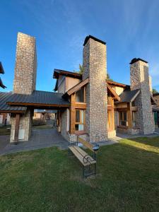 a building with two towers with a bench in the grass at Ayelen Andina in Esquel