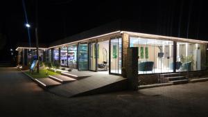 a building at night with glass windows and a bench at Thassos Hotel Grand Beach in Limenaria