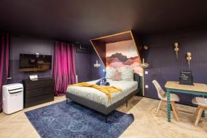 a bedroom with a bed and a desk and a tv at Doux Pavillon - 1001 nuits - Jaccuzi in Mulhouse