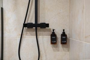 a shower with two soap bottles on the wall at Doux Pavillon - 1001 nuits - Jaccuzi in Mulhouse