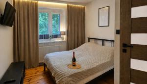 a bedroom with a bed with a bottle of wine on it at Bytom Apartament 24H in Bytom