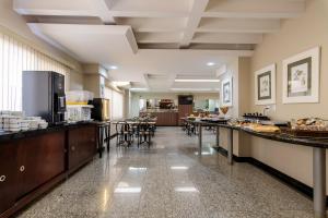 eine Cafeteria mit Buffet, Tischen und Stühlen in der Unterkunft Hotel Riviera in Sao Jose do Rio Preto