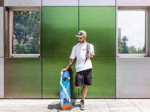 a man holding a skateboard in front of a building at Hotel ibis Budget Porto Gaia in Vila Nova de Gaia