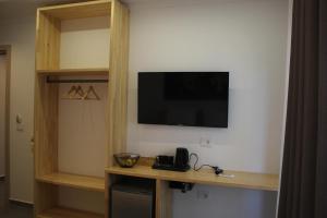 a room with a television on a wall with a shelf at Lazari S Apartments in Himare +35 photos