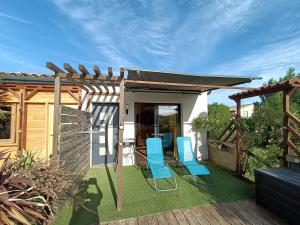 a patio with two chairs and a pergola at La cabane des jours heureux in Saint-Laurent-de-Carnols
