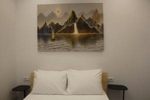 a bedroom with a bed with a painting on the wall at Lazari S Apartments in Himare