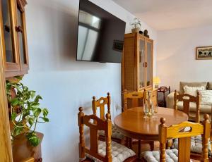a dining room with a wooden table and chairs at La terraza del Campanario in Ríolobos