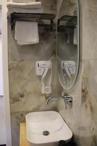 a bathroom with a toilet and a mirror and a sink at Lazari S Apartments in Himare