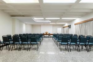 ein leerer Raum mit Stühlen, einem Tisch und einem Bildschirm in der Unterkunft Hotel Riviera in Sao Jose do Rio Preto + 52 Fotos