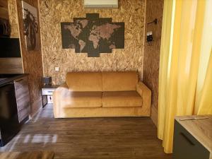 a couch in a living room with a map on the wall at La cabane des jours heureux in Saint-Laurent-de-Carnols