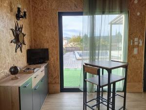a kitchen with a counter and a table and a window at La cabane des jours heureux in Saint-Laurent-de-Carnols