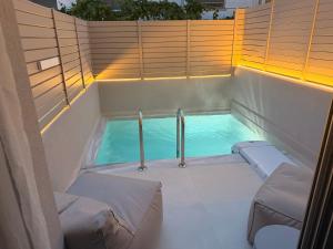 a swimming pool with two beds and a tub at LaK Private Pool Suites in Potos,Thassos in Potos