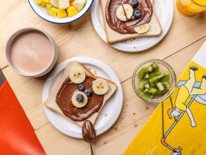 three plates of food with pancakes and fruit on a table at ibis budget Thonon Les Bains in Thonon-les-Bains