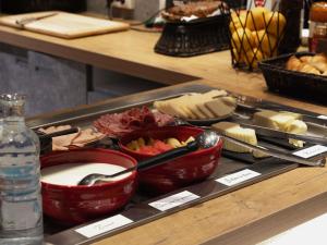 a tray with bowls of food and a bottle of water at ibis budget Thonon Les Bains in Thonon-les-Bains