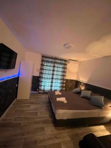 a bedroom with a large bed and a large window at Willow Apartmant in Harkány