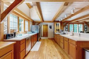 a large kitchen with wooden cabinets and white counter tops at Glen Road Lodge in Peru +41 photos