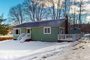 a small green house with snow on the ground at Strollski Cottage in Ludlow