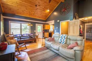 a living room with a couch and a pool table at Misty Mountain Cabin in Lenoir