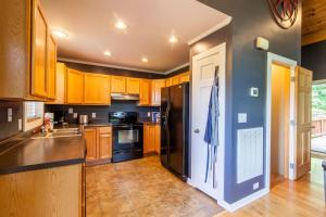 a kitchen with wooden cabinets and a black refrigerator at Misty Mountain Cabin in Lenoir